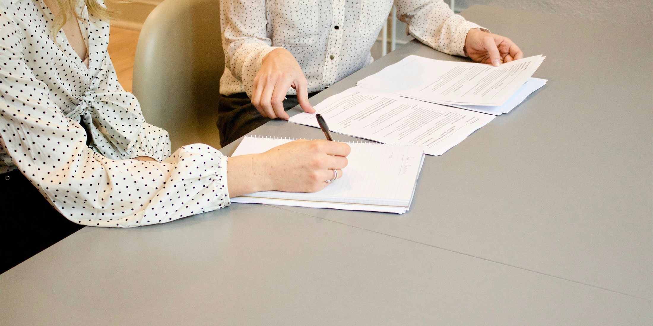 Two people reviewing documents together at a desk