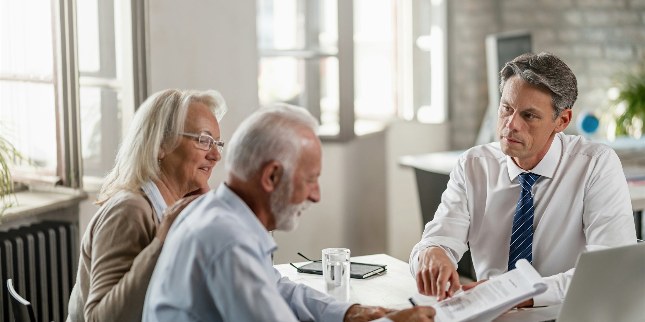 An advisor discussing plans with two clients at a table
