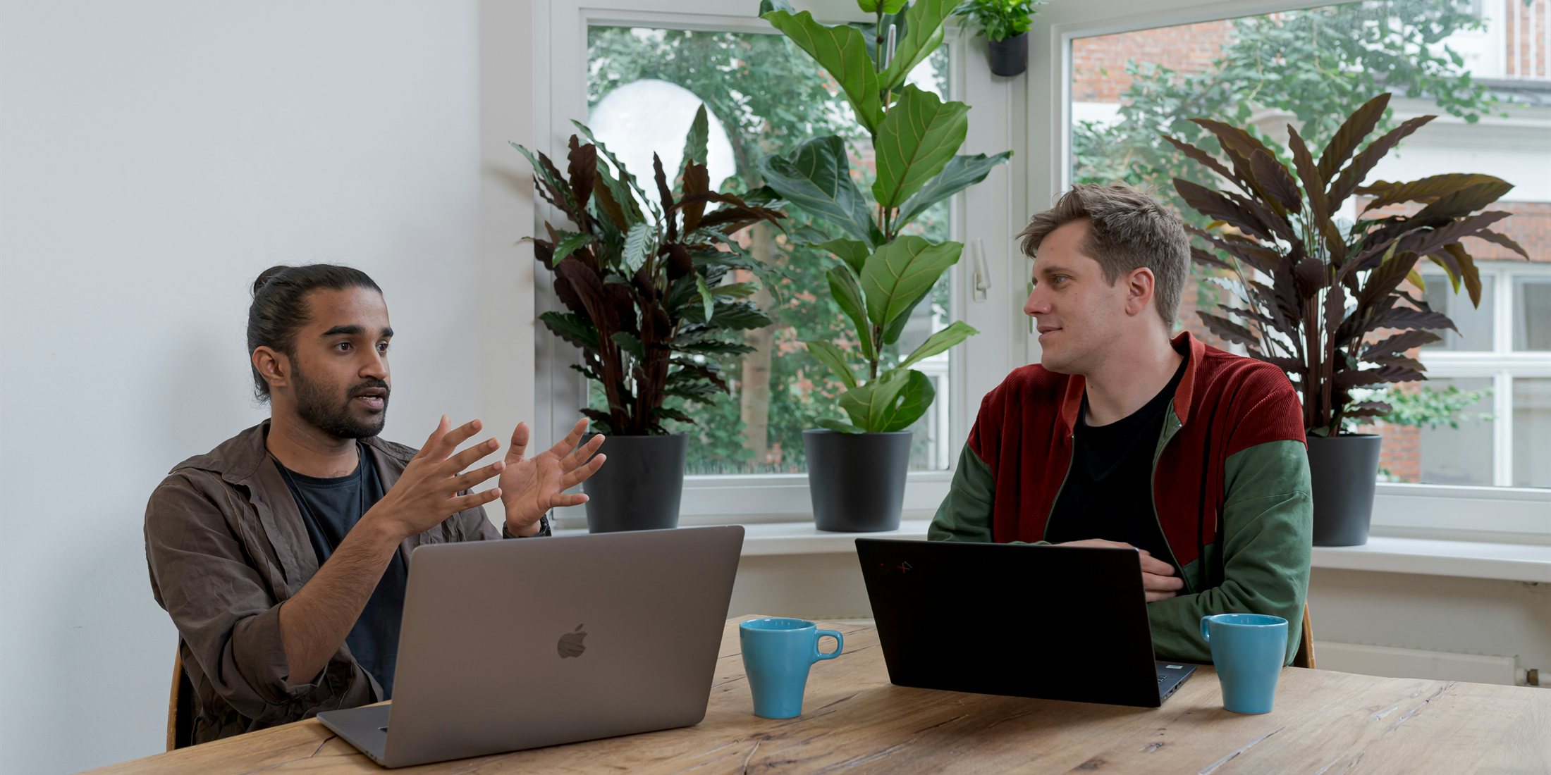 Two people discussing a business at a table with laptops